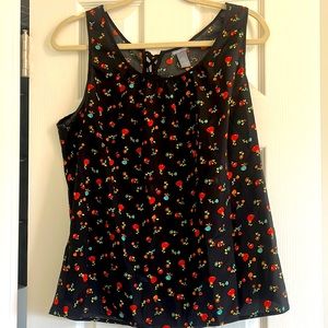 Black/pattern sleeveless top with cross ties at the back & cutout at the back